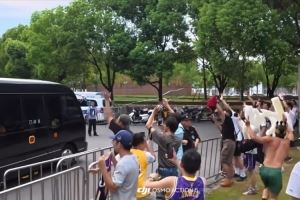 詹姆斯乘车离开交大校园 男球迷赤膊高举King字牌一路狂奔追随